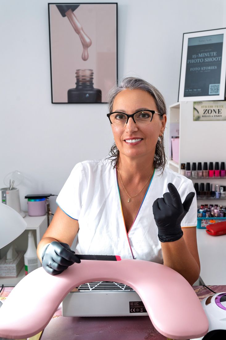 Beata in weißer Arbeitskleidung und mit Handschuhen am Maniküretisch, Bahia Nails, La Herradura